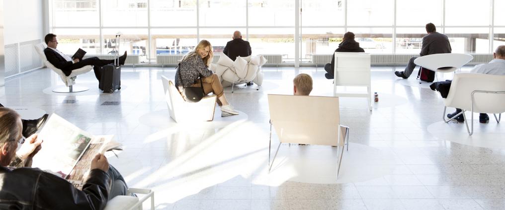 Ihimiset odottavat kirkkaan valkoisessa aulassa.