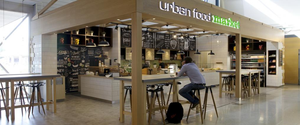 Mies istuu pöydän ääressä ravintolan edessä.