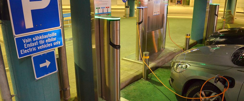 Sähköauto latauksessa parkkialueella.
