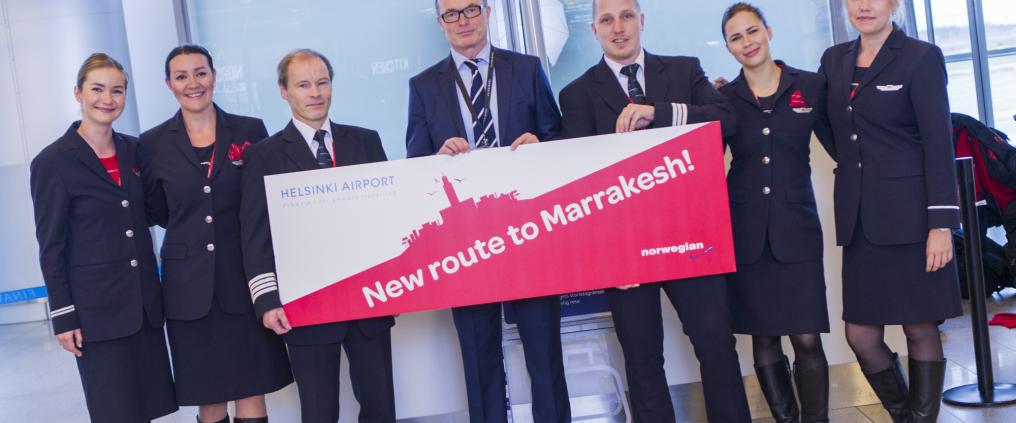 Norwegian employees holding a signboard about new flight route.