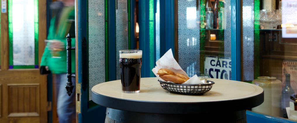 Oak Barrel store front with drink and food on barrel table.