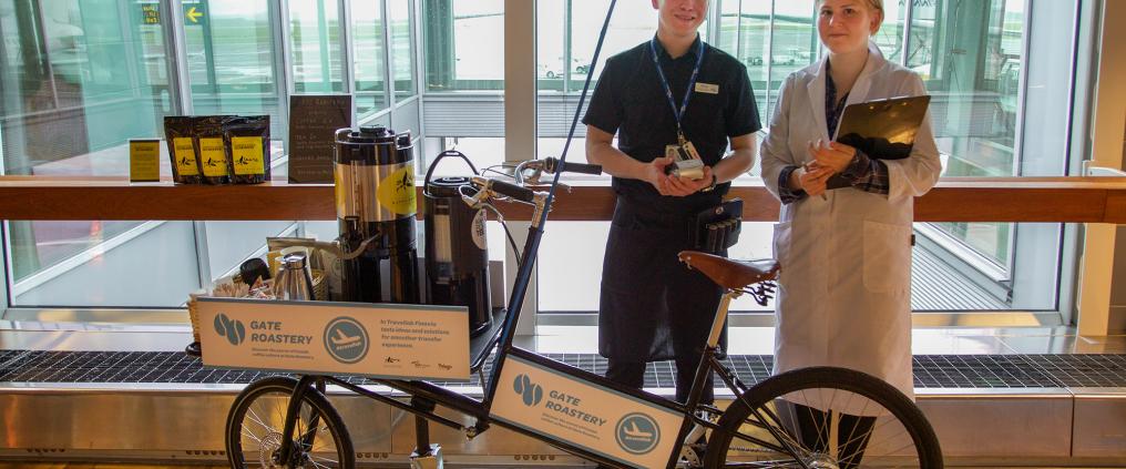 Two persons in front of a popup coffee shop.
