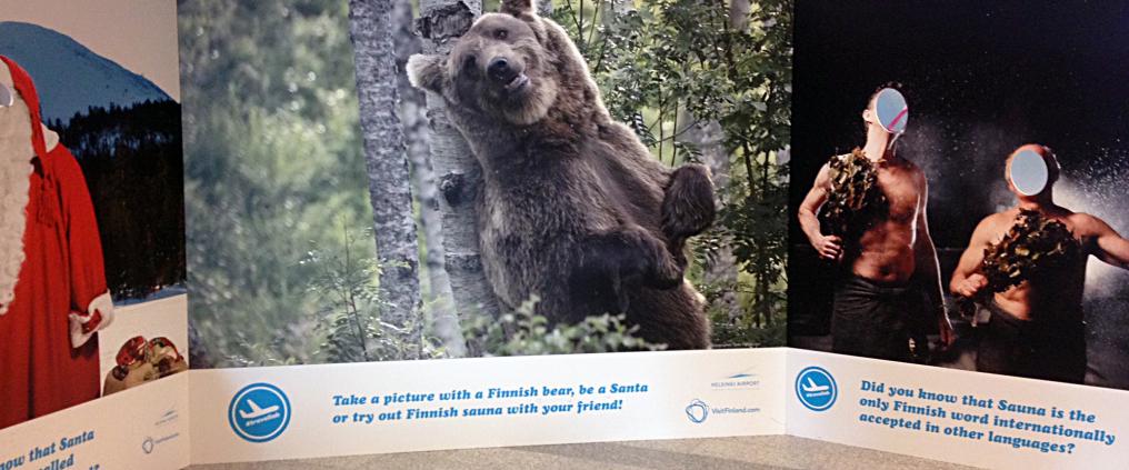 Kuva joulupukista, karhusta ja kahdesta miehestä saunassa.