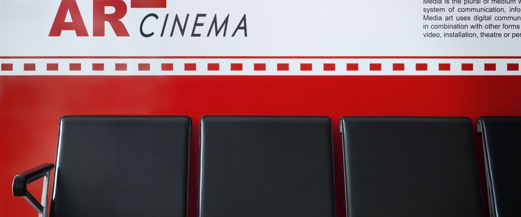 Mustat penkit seinämaalauksen edessä.