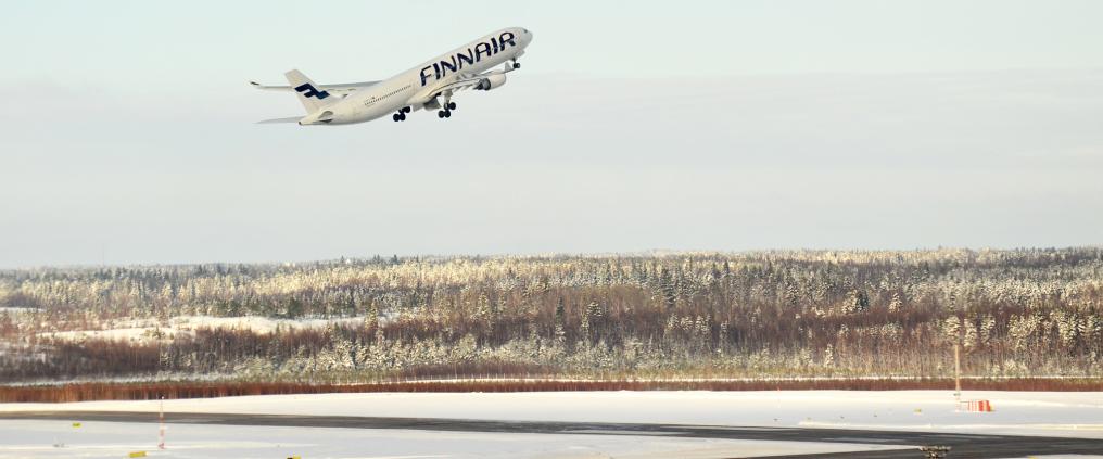 An finnair airplane taking off during winter.