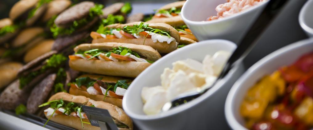 Sandwitches and sallads on table.