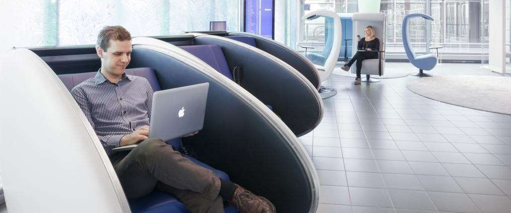 A man using laptop at a lounge.