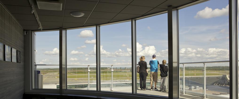 Perhe katselee Helsingin lentokenttää näköalaterassilta.