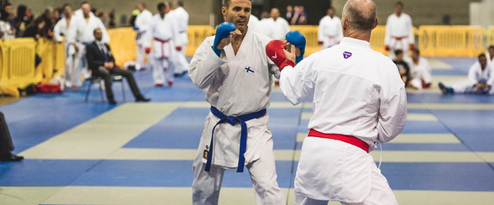 Kaksi miestä nyrkkeilemässä tatamilla.