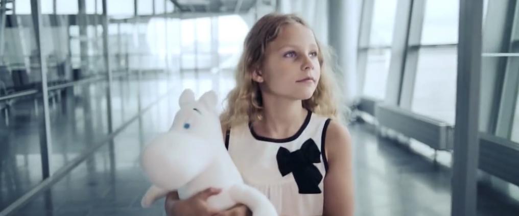 Child walking in Helsinki Airport holding a Moomin soft toy.