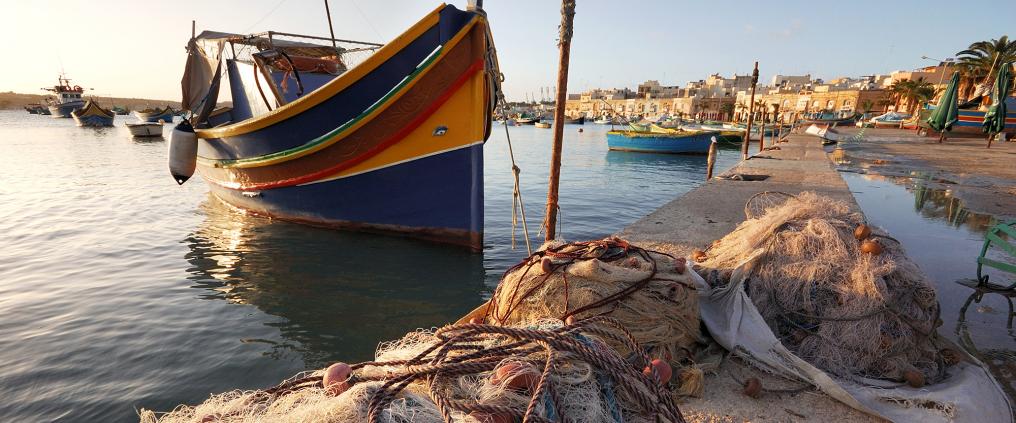 Värikäs kalastusvene Maltan venesatamassa.