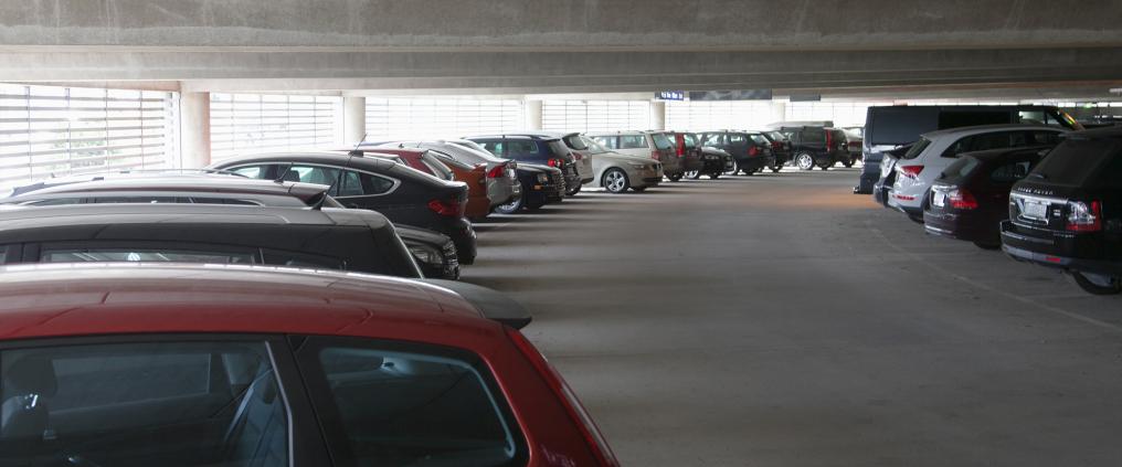 Multiple of cars parked in a parking hall.