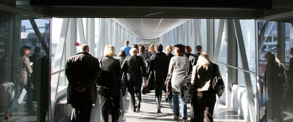 Passengers walking to non-Schengen gates through a glass bridge.