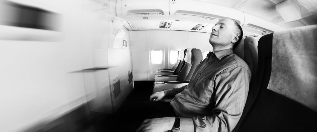 A man sleeping on board an airplane.