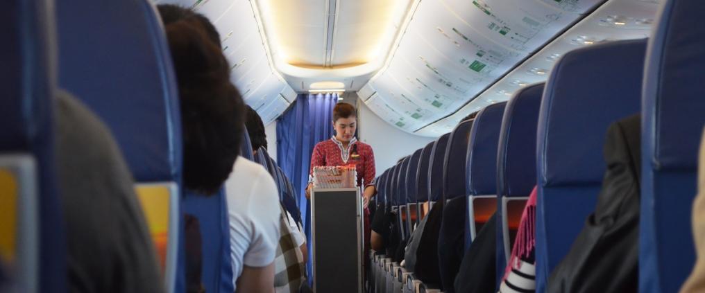 Food serving is starting on cabin aisle.