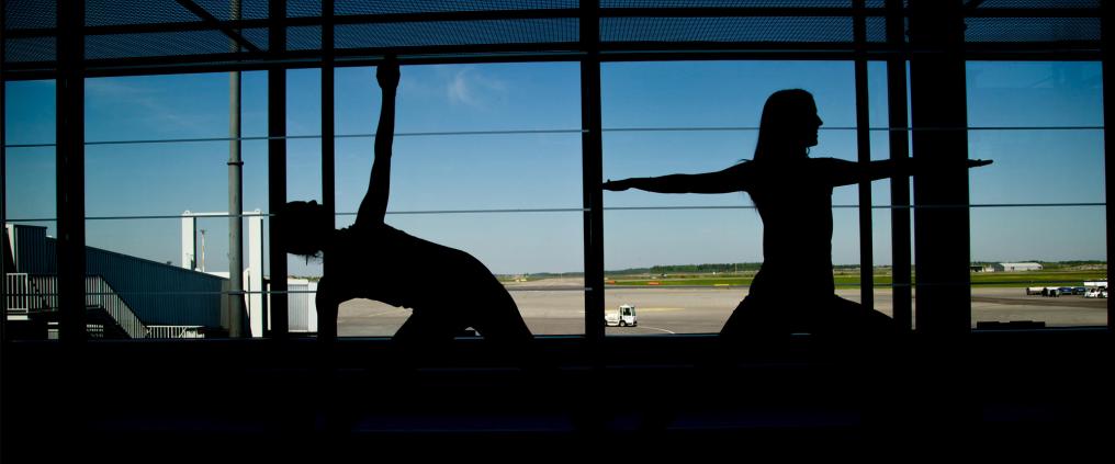 Joogaavien ihmisten silhuetit.