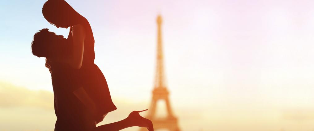 Couple being romantic in Paris with Eiffel Tower in the background.