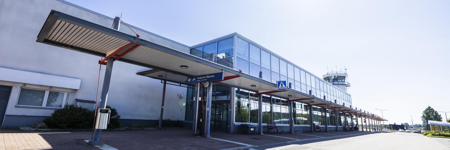 Kuopion lentoaseman pääsisäänkäynti ja edusta kuvattuna aurinkoisena päivänä.