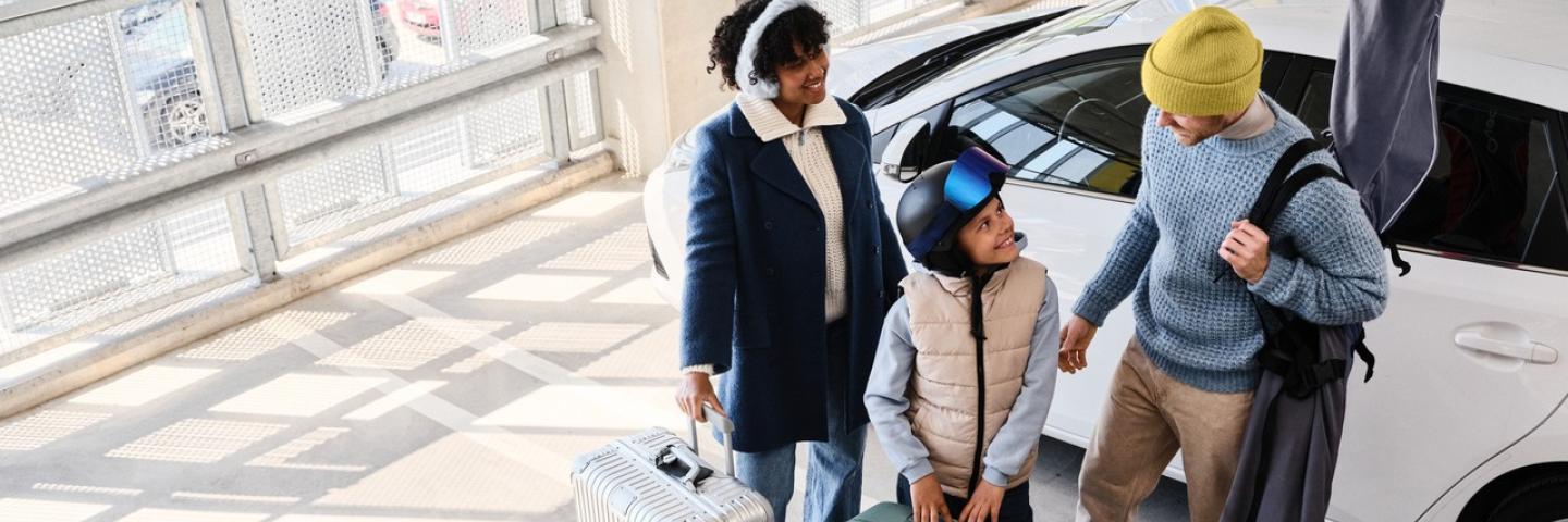 Perhe Helsinki-Vantaan lentoaseman pysäköintitalossa lähdössä matkalle