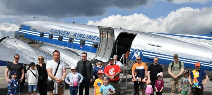 Lapsia ja aikuisia vanhan DC3-koneen edessä