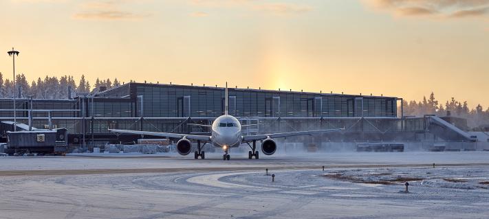 Talvinen kuva lentokoneesta ja terminaalirakennuksesta.
