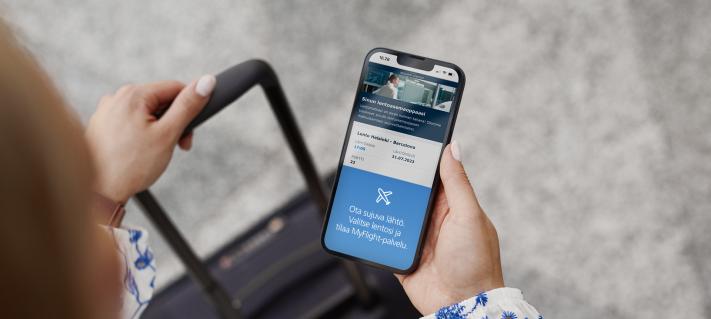 Matkustaja katsoo MyFlight -palvelua kännykästään.