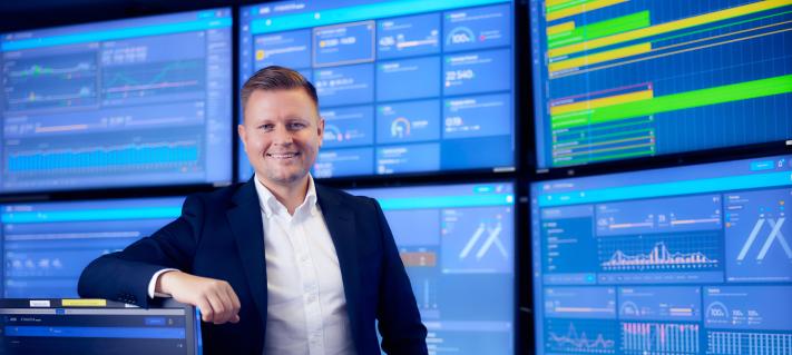 Jani Ceder Finaviasta hymyilee tietokonenäyttöjen edessä.