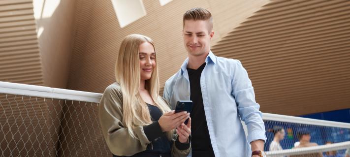 Matkustajat hymyilevät terminaalissa