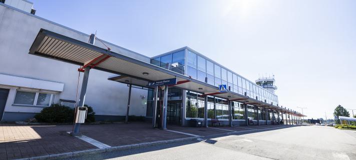 Kuopion lentoaseman pääsisäänkäynti ja edusta kuvattuna aurinkoisena päivänä.