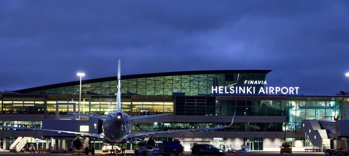Helsinki-Vantaan lentoaseman terminaali ja asematasolla odottava lentokone kuvattu yöaikaa.
